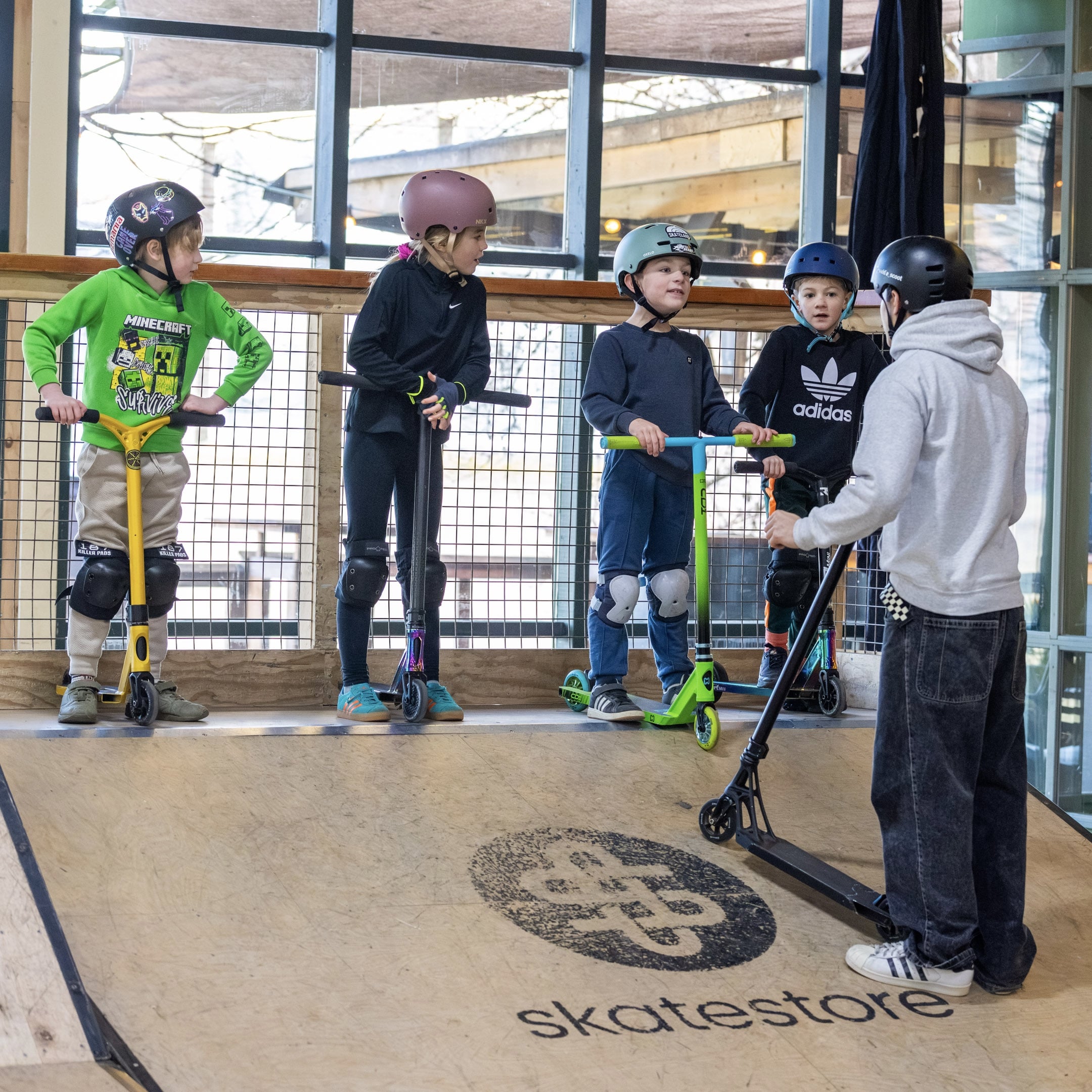 Kinderen krijgen uitleg tijdens een stuntsteples op een ramp bij Skateland