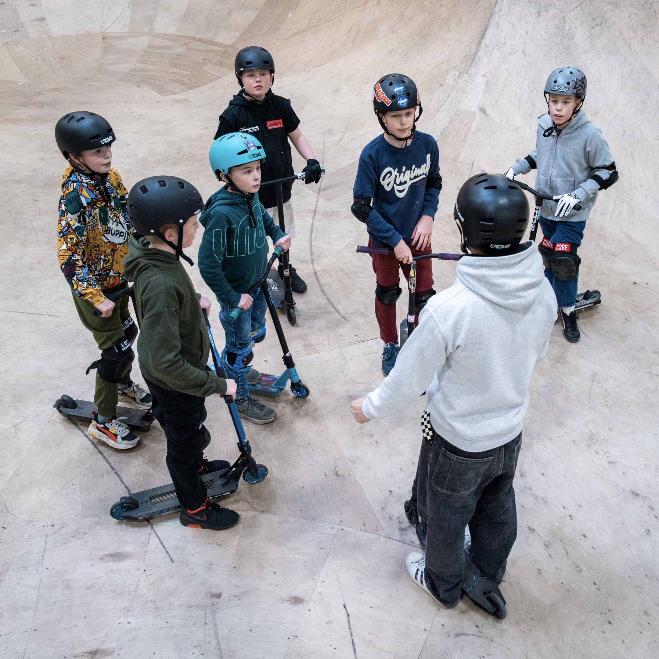 Groep kinderen verzamelt zich tijdens een stuntsteples met instructeur