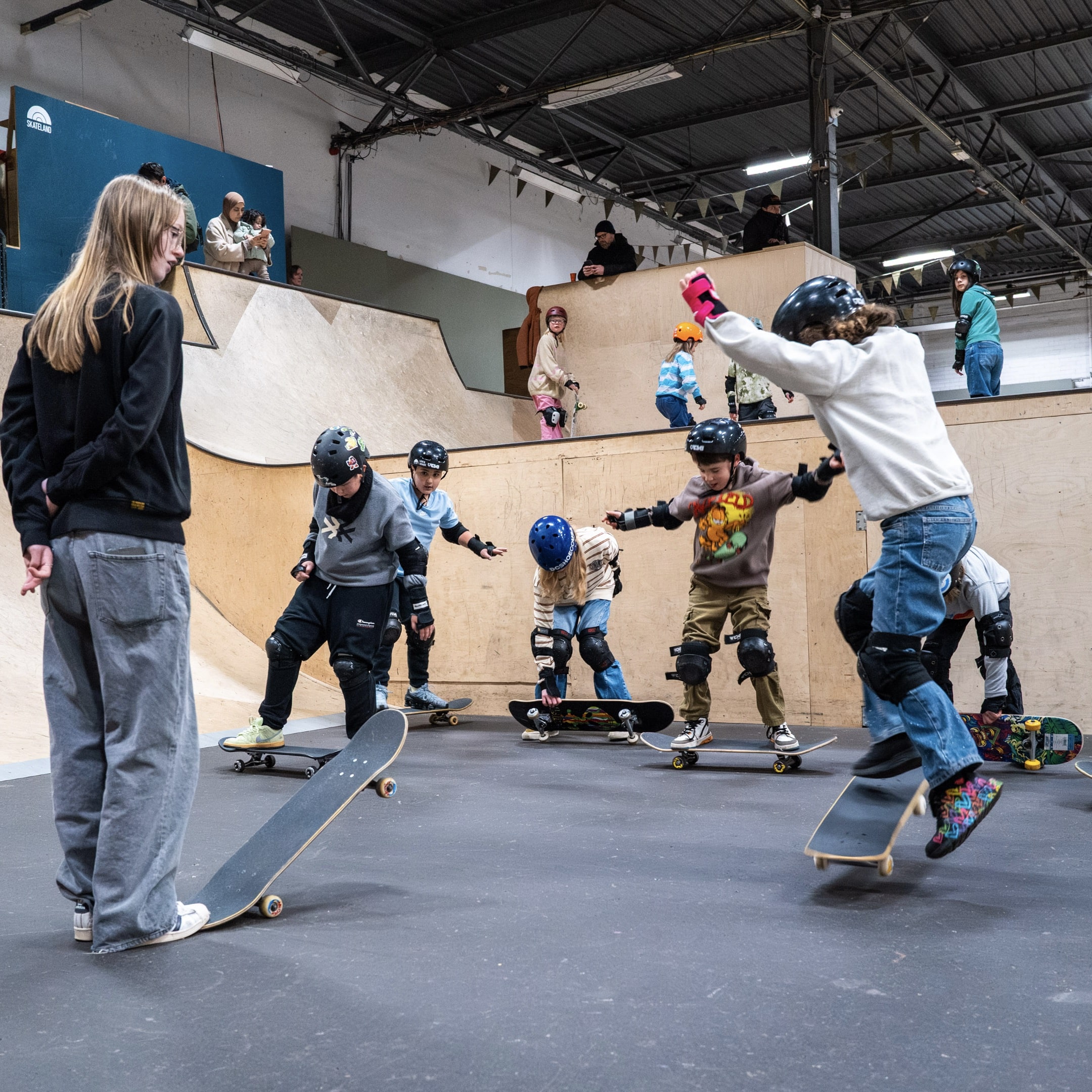 Kinderen oefenen basisvaardigheden tijdens een skateboardles